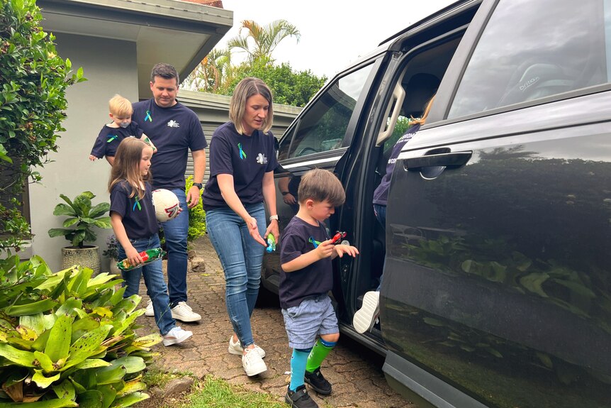 Parents helping children get into the car