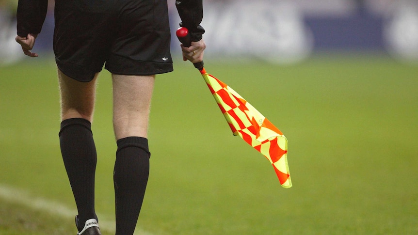 Photo of an unidentified soccer linesman and his flag.