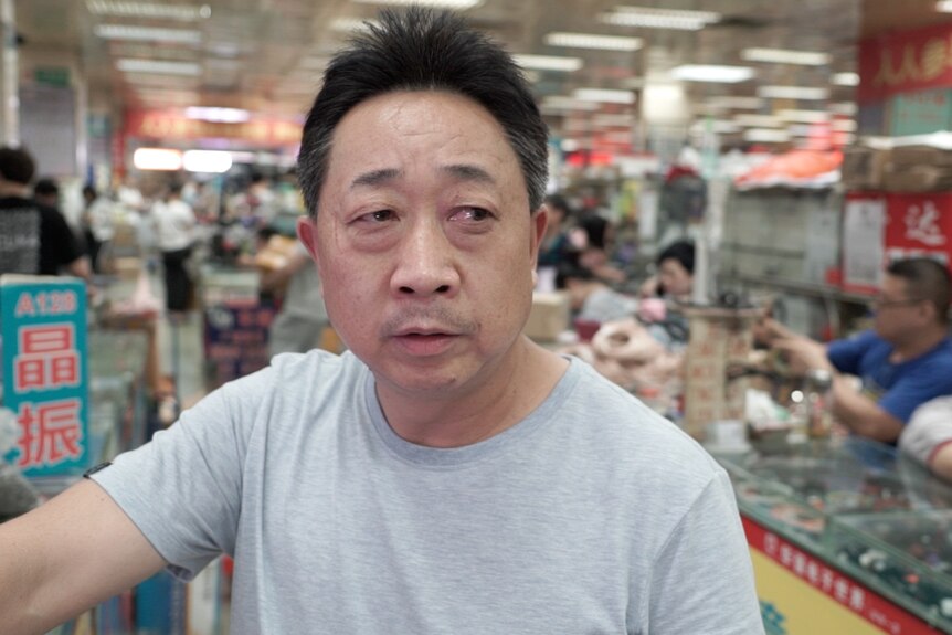 A man looking thoughtful in an electronics market