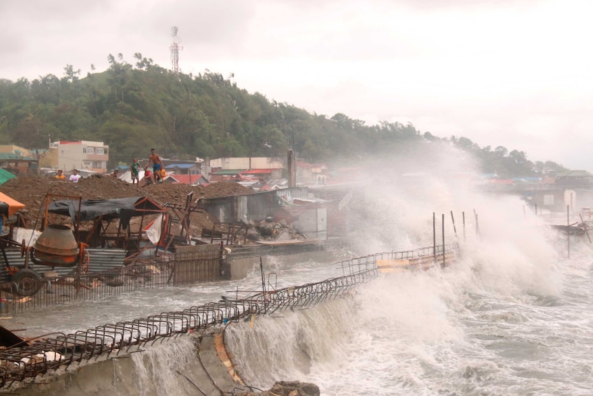 Strong waves batter houses along the coastline