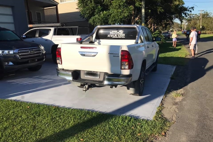A car parked illegally on a driveway. 