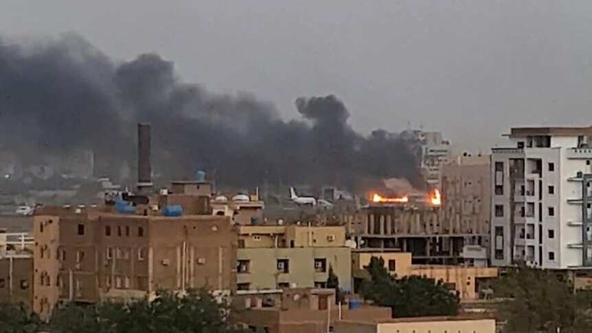 Smoke rises from the tarmac of Khartoum International Airport as a fire burns, in Khartoum.