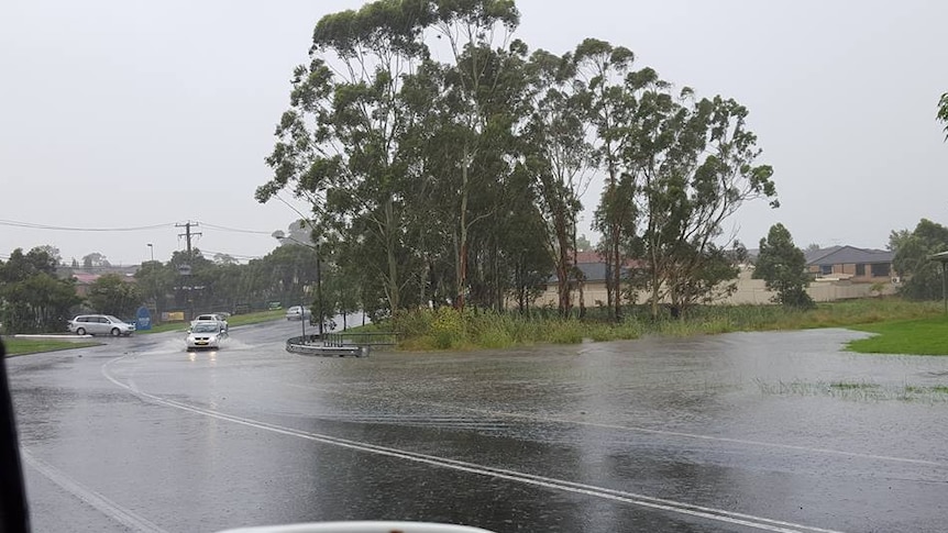 Floodwaters swamp a road in Newcastle amid heavy rain falls.