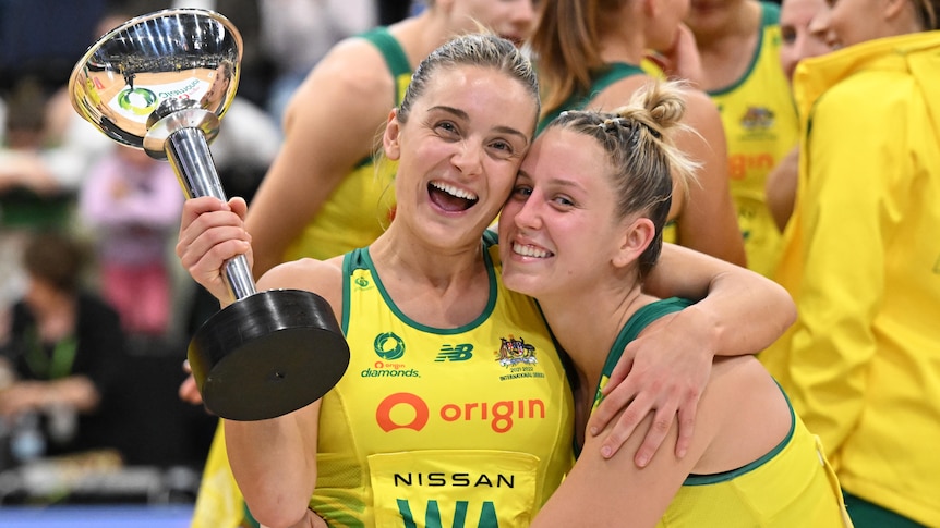 Liz Watson and Jamie-Lee Price smile and hug while Watson holds the Constellation Cup