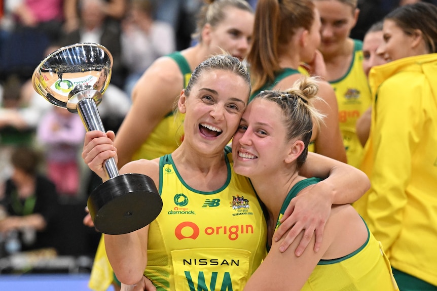 Liz Watson and Jamie-Lee Price smile and hug while Watson holds the Constellation Cup