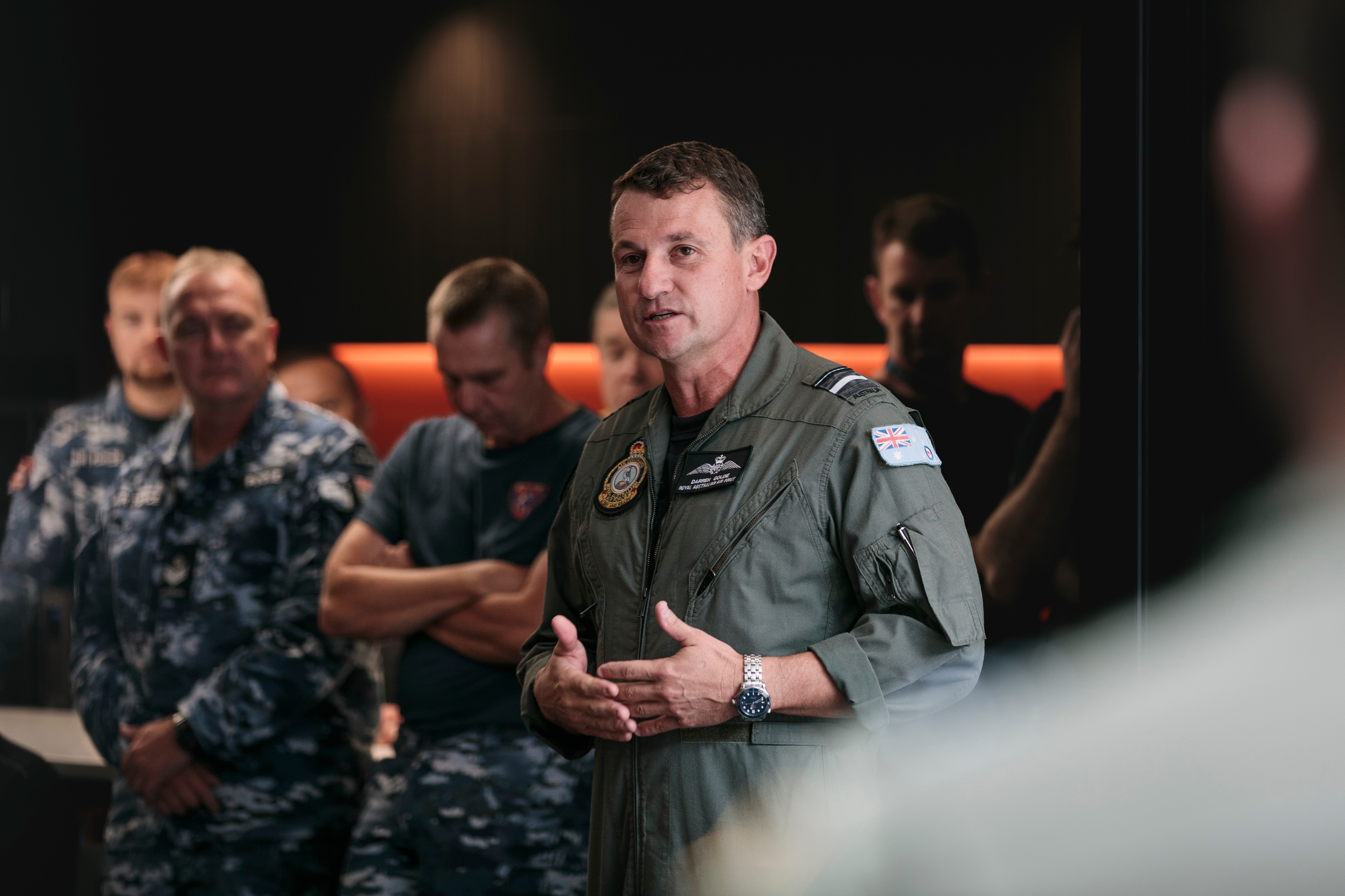 A man in military uniform speaks to a crowd.