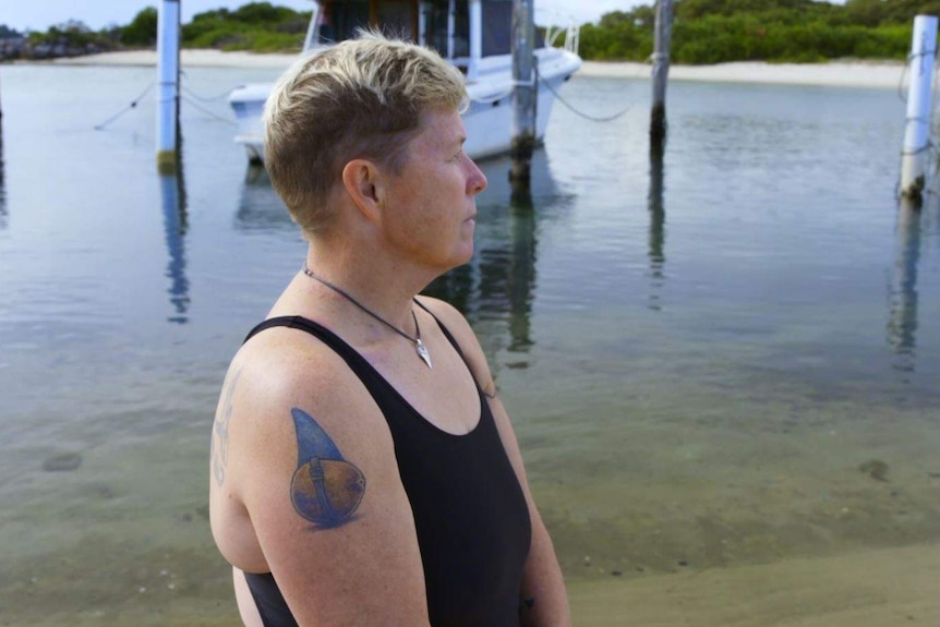 The side profile of a woman looking out over water.