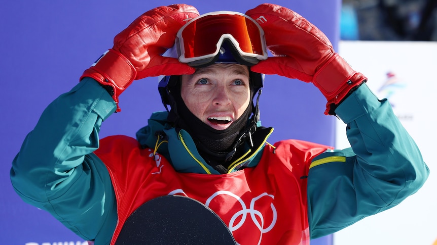 Australian snowboarder Scotty James looks up at the scoreboard at the Winter Olympics as he lifts his goggles off his face.