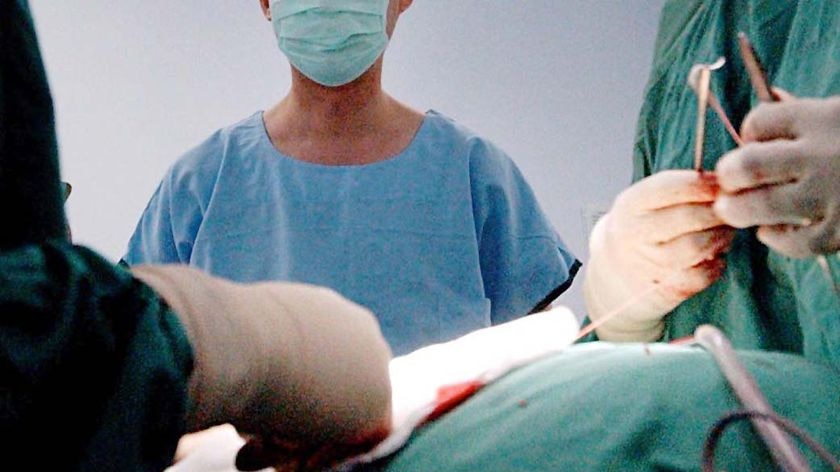 A close-up of gowned surgeons in an operating theatre.