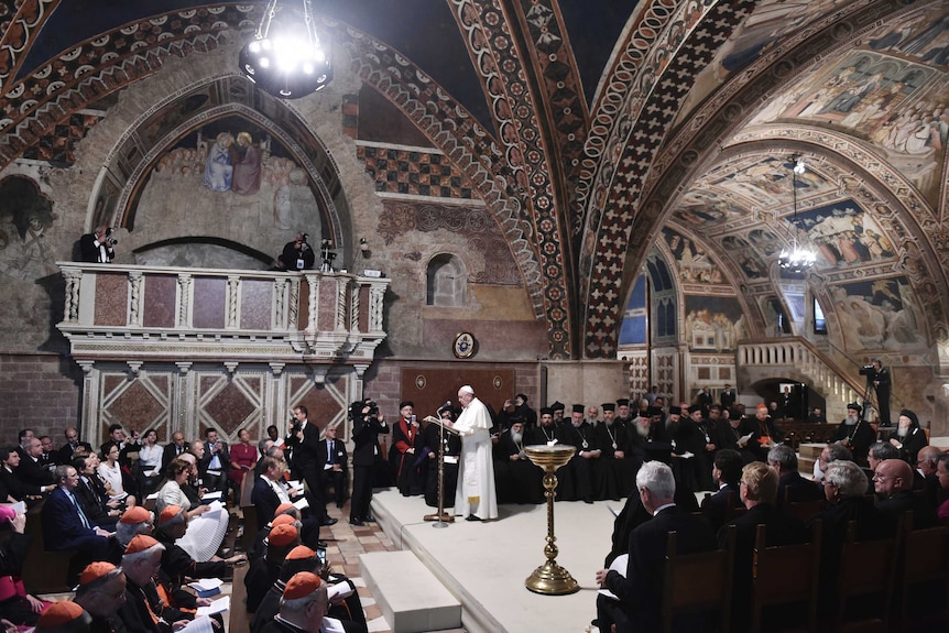 The Pope gives mass in a painted basilica packed with people.