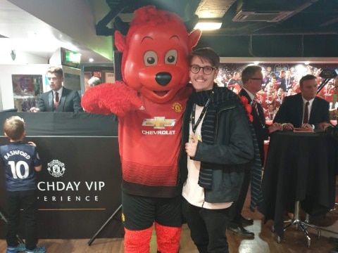 Riley posing with the Manchester United mascot Fred the Red. 
