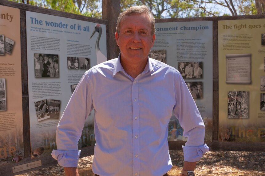 Reece Whitby stands in front of a row of information boards at the new national park.