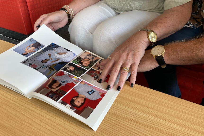 Couple's hands on photo album of their son