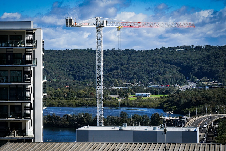A crane at a building site in Gosford with water views in the background.