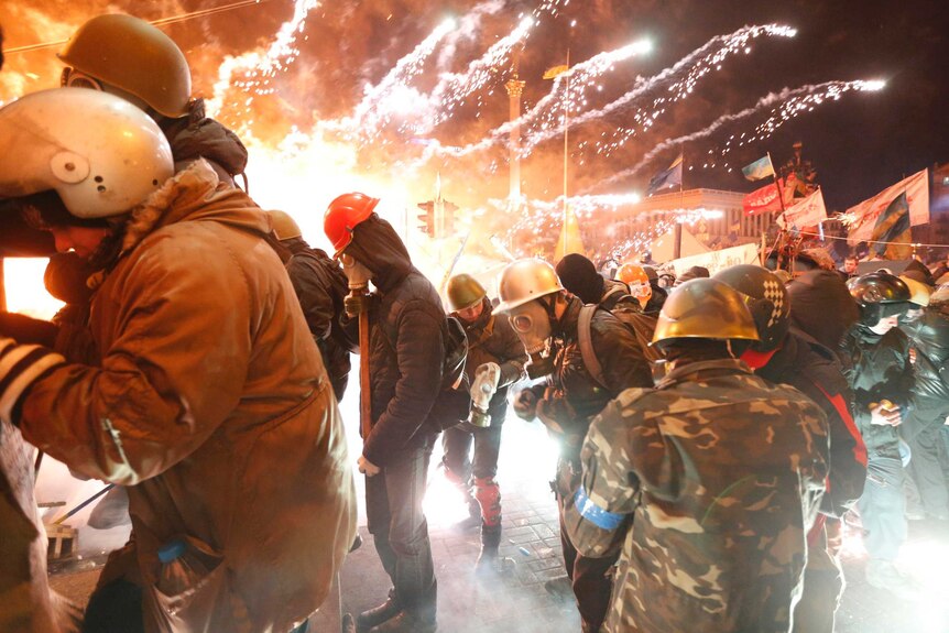 Anti-government protesters use fireworks during clashes with riot police in Kiev.