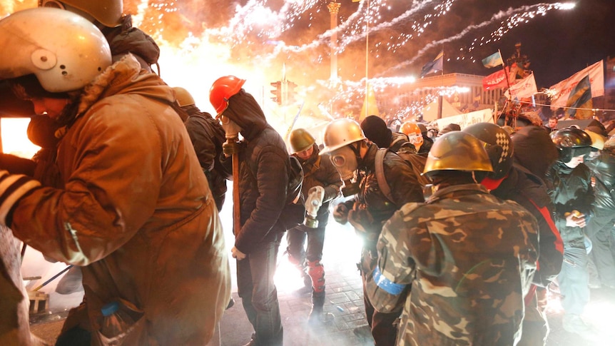 Anti-government protesters use fireworks during clashes with riot police in Kiev.