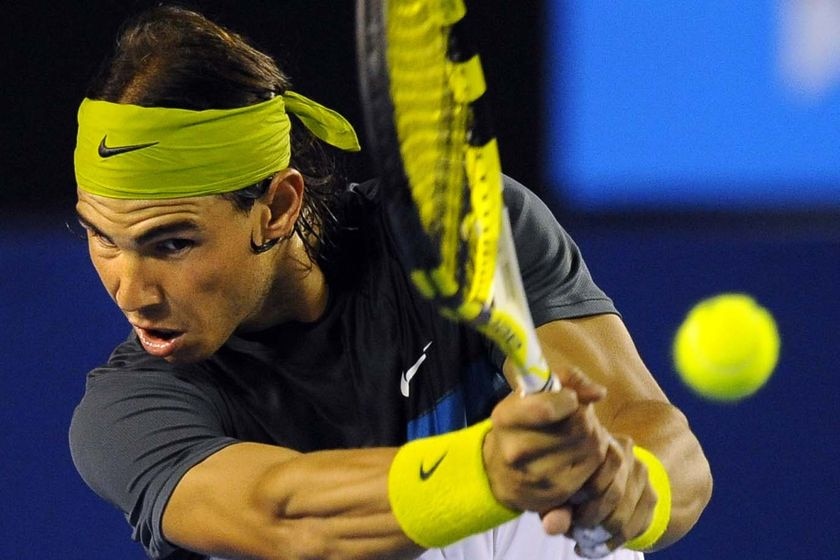 Nadal grimacing as he makes the shot