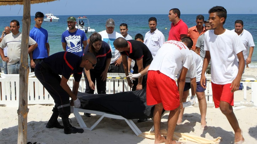 Tunisian lifeguards and medics transport a covered body in Sousse