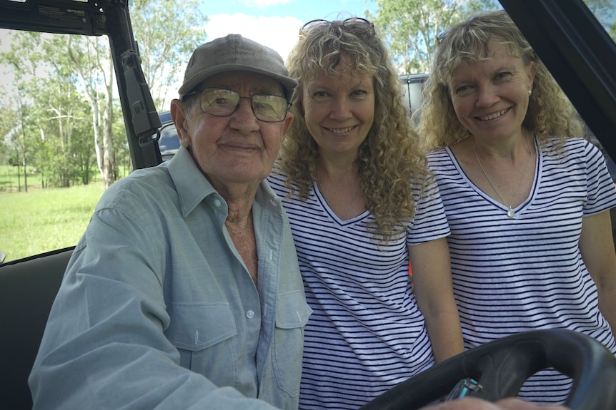 Twin sisters stand with Bob Irwin, all smiling