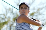 Lexi Thompson finishes a swing with the golf club over her shoulder on a sunny day.