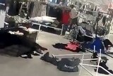 A man is seen pulling down racks of clothing in a H&M store in South Africa.