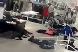A man is seen pulling down racks of clothing in a H&M store in South Africa.