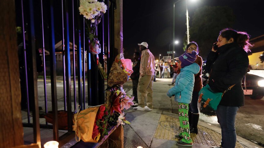 Flowers and candles are placed at the site of a warehouse fire
