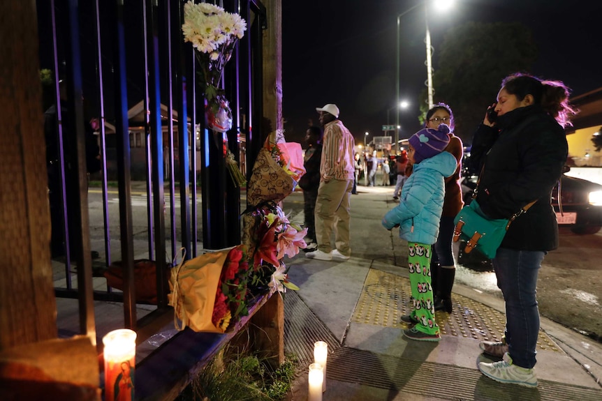 Flowers and candles are placed at the site of a warehouse fire