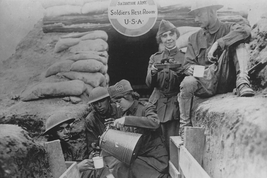 Women giving officers doughnuts in the trenches of World War I.