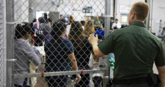 Officer stands at the cage-fenced door