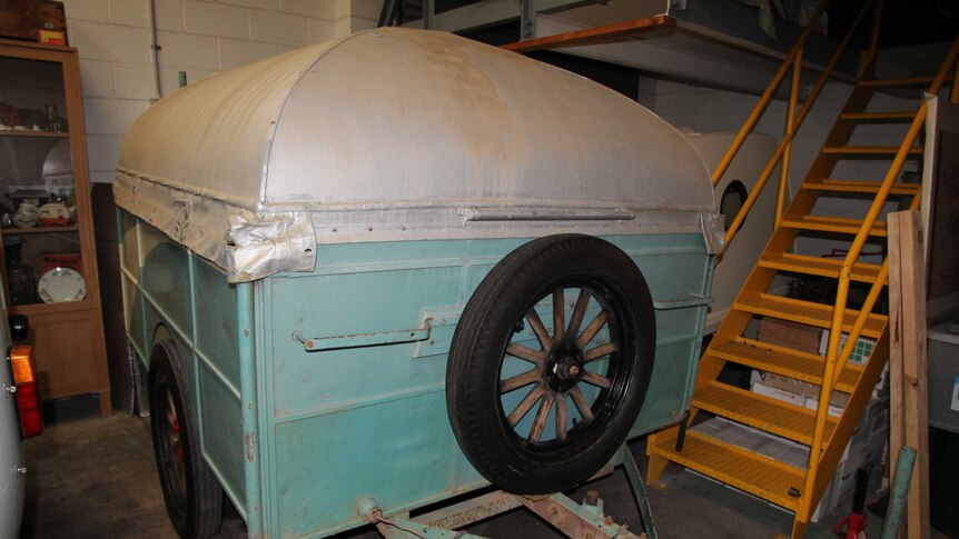 A vintage Eicke and Provis 1936 pop-up caravan parked in a shed