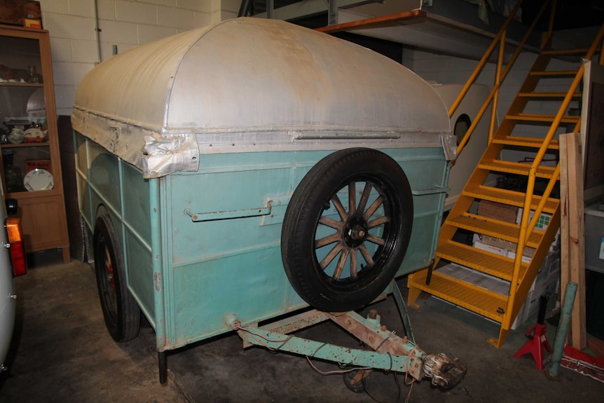 A vintage Eicke and Provis 1936 pop-up caravan parked in a shed