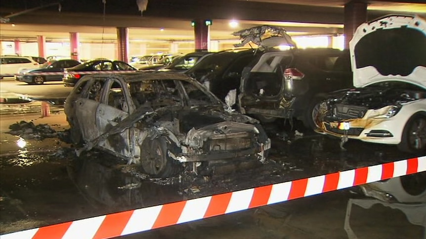 Cars showing serious fire damage.