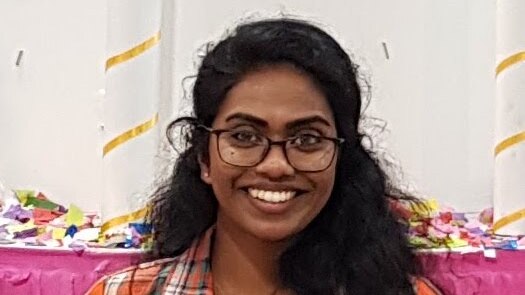 Dasunika Tennakoon wearing glasses, smiles at the camera
