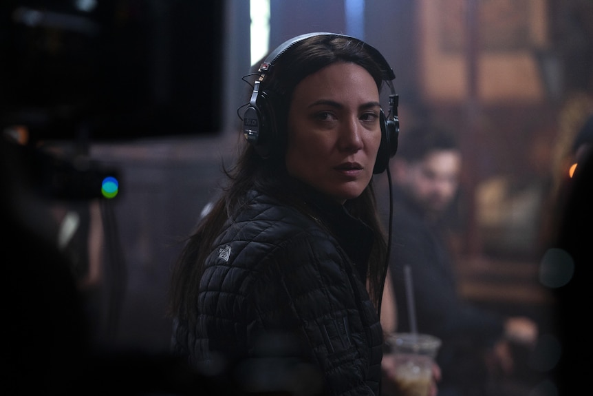 A woman on a film set wearing headphones.