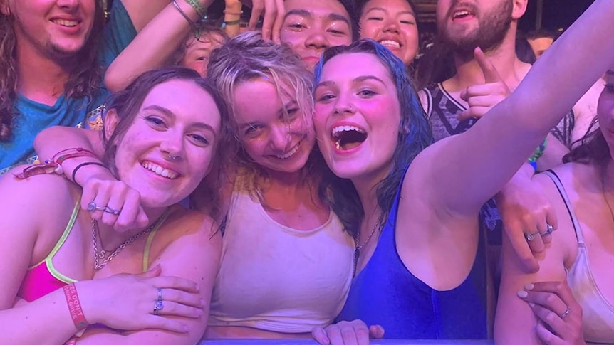 A group of young people at a music festival front row.