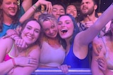 A group of young people at a music festival front row.
