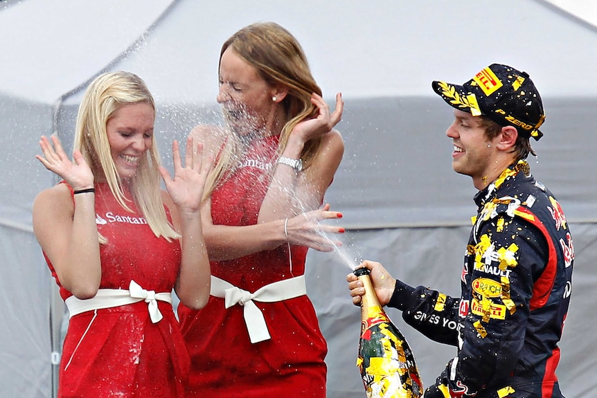 Sebastian Vettel showers champagne at grid girls at the German F1 Grand Prix.