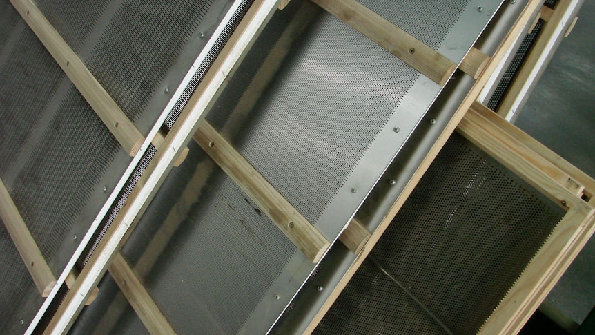 A stack of perforated plates used to sieve and clean vegetable seeds