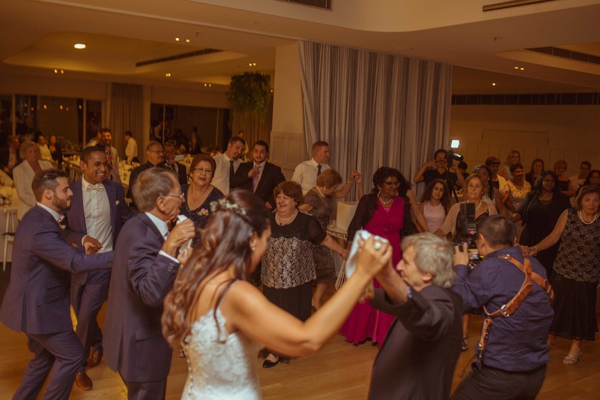 Guests celebrate Chris and Eleni's marriage with traditional Greek dancing.