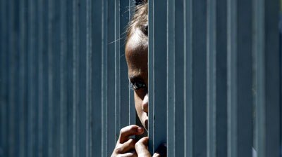 A girl looks out from the gates of her home in the East Timorese capital of Dili.