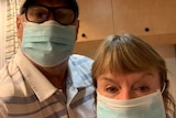 A man and a woman wearing face masks