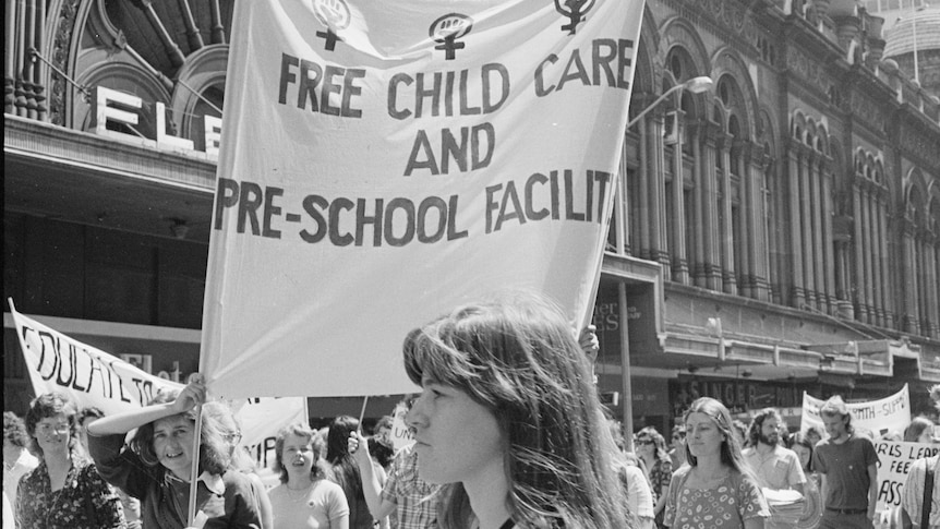 1970s womens march with banner calling for free childcare 