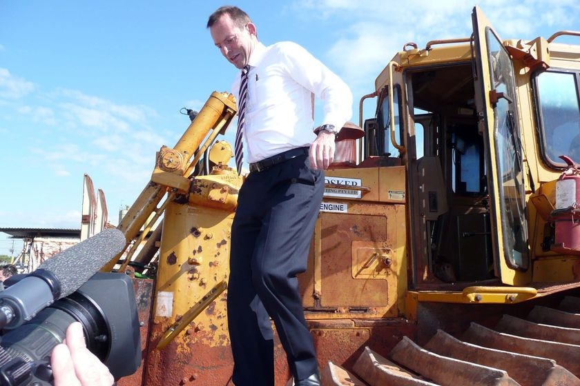 Tony Abbott gets down from a bulldozer while campaigning in Gladstone