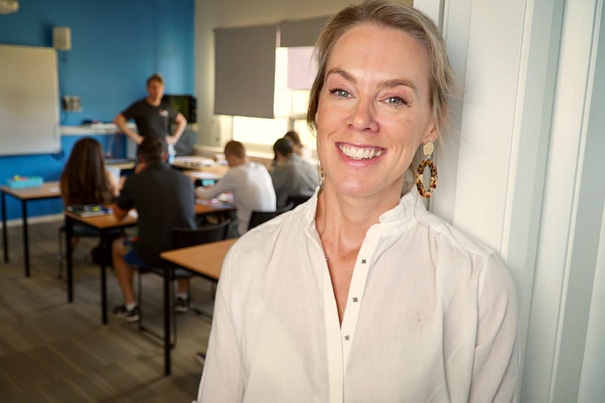 Abby Barrett stands at the doorway of a classroom