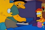 An animation shows three yellow Simpsons figures crowded around character Lisa Simpson's blue bed as one plays a piano.