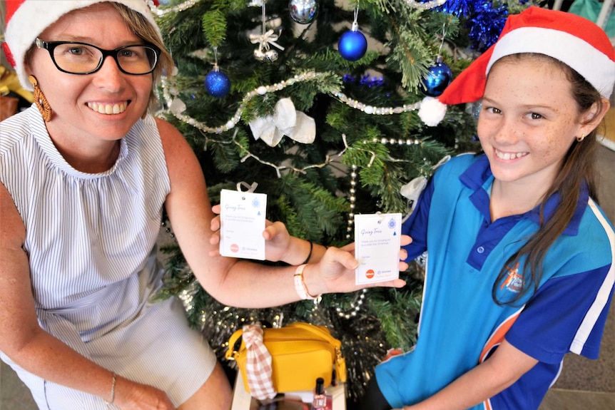 mum and daughter with St Vincent de Paul ABC Radio Darwin Christmas appeal giving tree gift tags