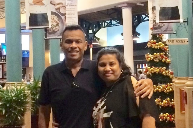 Sprent Dabwido is pictured standing with his arm around his wife Linda Dabwido in a food court.