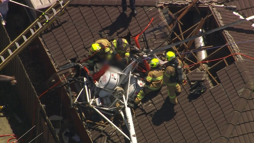 Emergency workers attend a helicopter crash into a roof.
