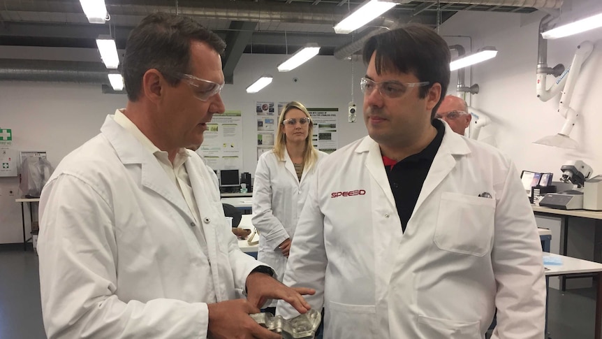 NT Chief Minister Michael Gunner holding a metal part made by the new 3D printer.